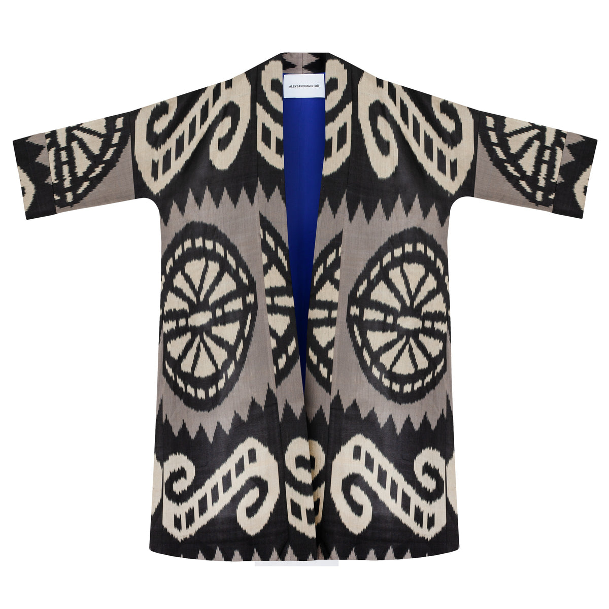Laura ikat coat flat lay front, open — large ikat rosettes and swirls, royal blue lining