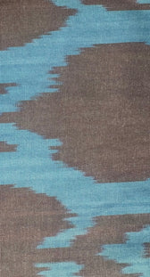 Aleksandra Viktor luxury ikat cotton fabric close-up — handwoven ikat weaving detail in blue and brown pattern by master artisans
